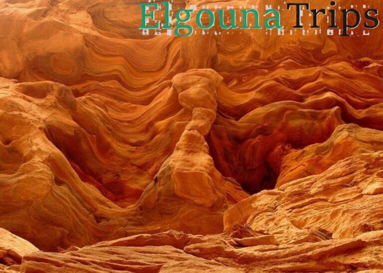 Dramatic swirling orange rock formations at Hurghada Canyon Safari and Mountain Hiking.